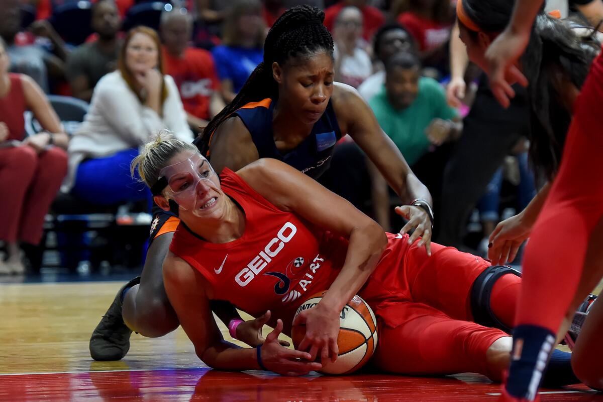 Washington's Elena Delle Donne, bottom, battles Connecticut's Jonquel Jones for the ball during the first half of Game 1 of the WNBA Finals on Sunday.