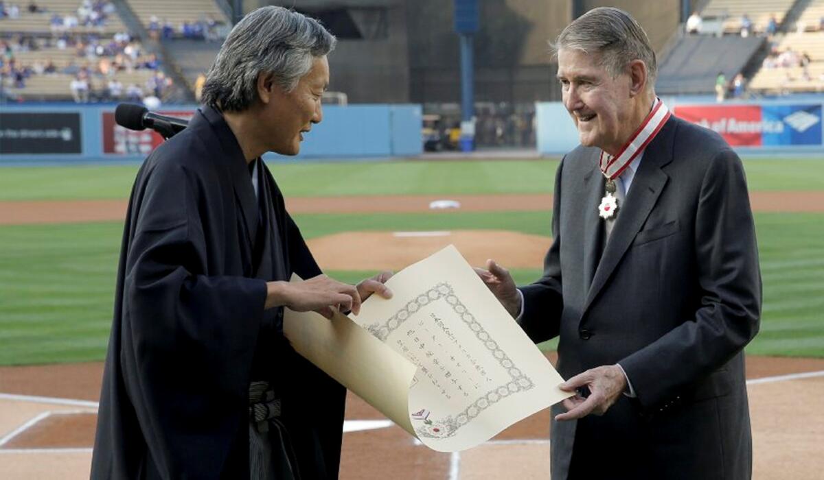 Former Dodgers President Peter O'Malley, right, receives the Order of the Rising Sun from the consul general of Japan in Los Angeles, Harry H. Horinouchi, as part of Japan Night at Dodger Stadium.