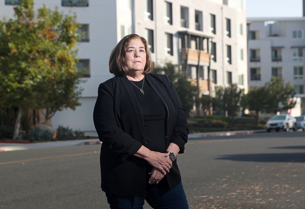 Costa Mesa resident Cynthia McDonald stands near Baker Block, a luxury apartment complex in Costa Mesa.