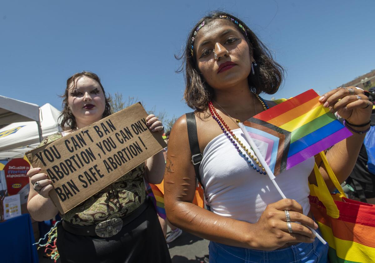 Elleana Tanner, of Laguna Hills, left, and Alejandra Barba, of Orange, attend the OC Pride festival in Santa Ana
