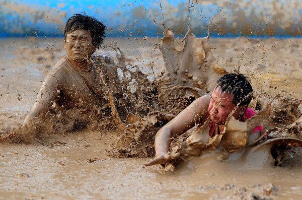 A Chinese participant dribbles the ball during a preliminary match in Beijing on August 10, 2011 for the up-coming Mud Football World Championships.