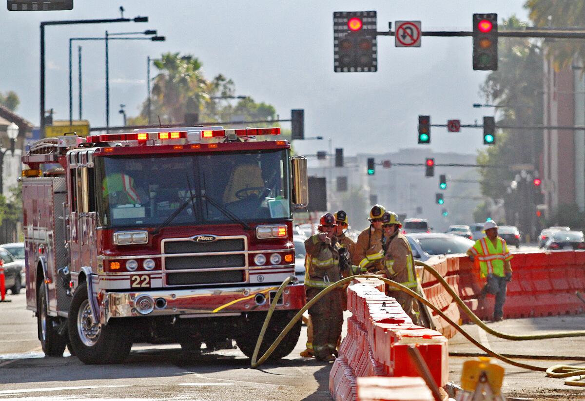 Glendale firefighters work at the scene of a ruptured 2-inch gas line damaged by a back hoe that ripped into the ground near Colorado Street and Brand Boulevard on Monday, June 30, 2014.
