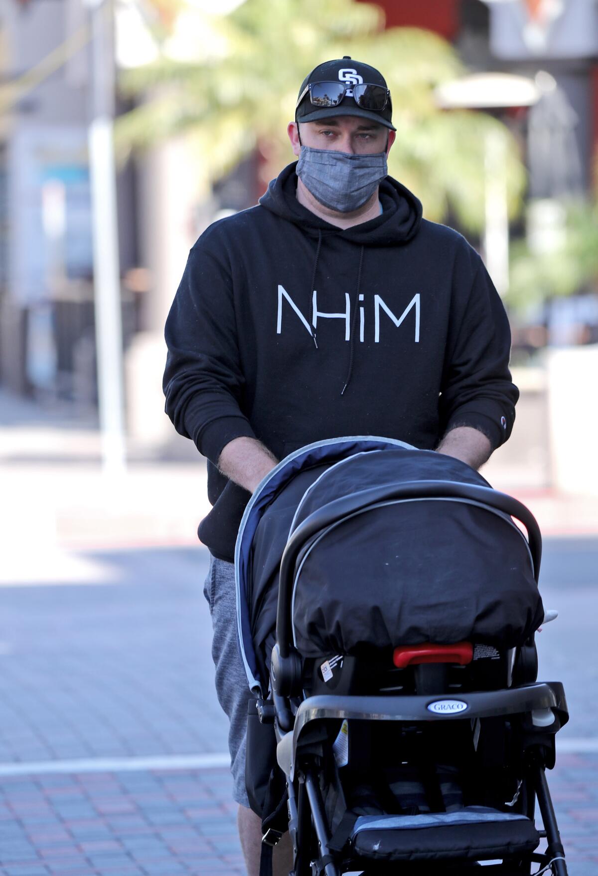 Phil Johnston, 27, of Orange pushes his baby girl in a stroller on the 100 block of Main Street on Wednesday.