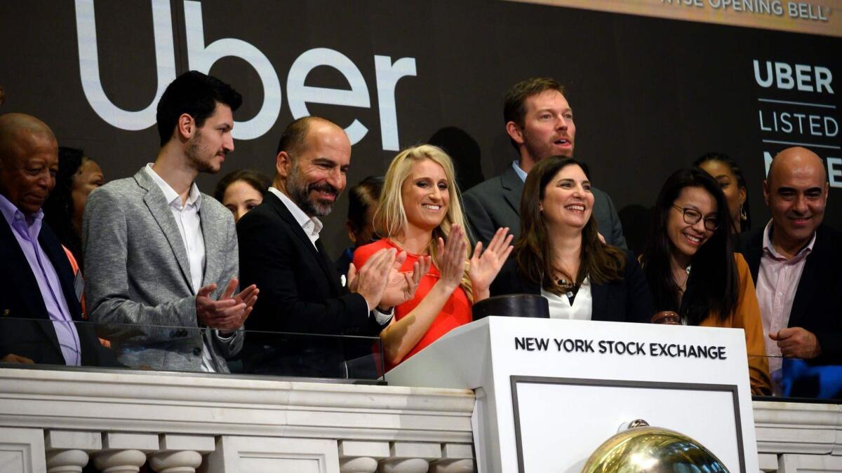 CEO Dara Khosrowshahi, third from left, rang the opening bell with early Uber employee and current executive Austin Geidt, center, at the New York Stock Exchange on Friday.