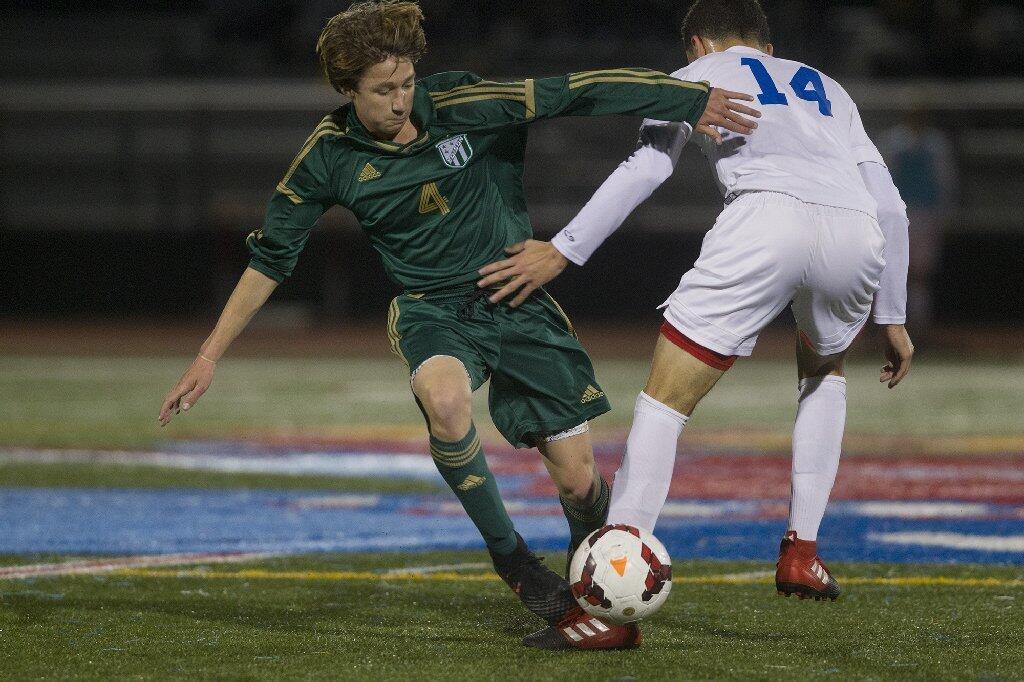 Edison High's Dustin Voorhees (4) battles for the ball during the first half against Los Alamitos.