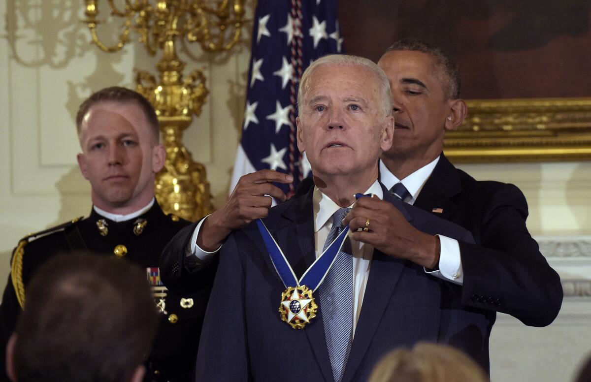 Then-President Obama hangs the Presidential Medal of Freedom around Joe Biden's neck.
