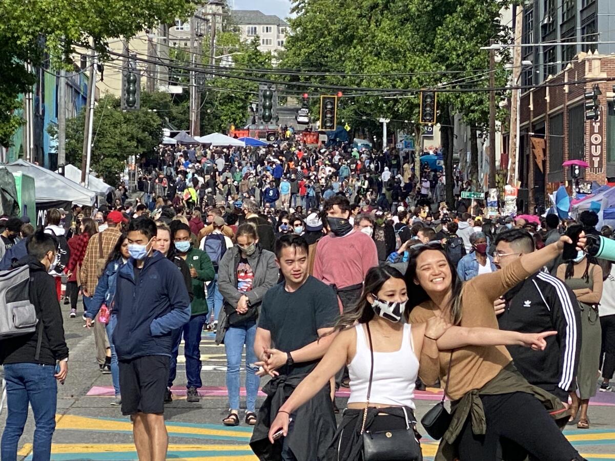 Two women celebrate in Seattle's protest zone June 13, as the area took on trappings of a street festival.