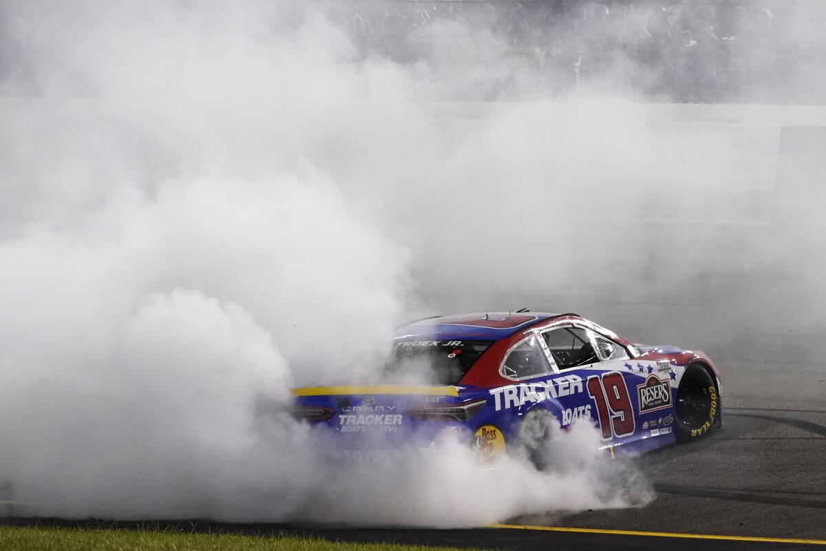 Martin Truex Jr. (19) does a burnout as he celebrates winning the NASCAR Cup series auto race in Richmond, Va., Saturday, Sept. 11, 2021. (AP Photo/Steve Helber)