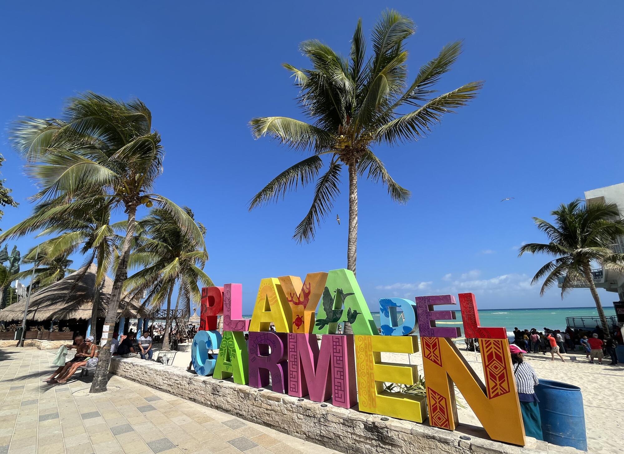 A colorful beachside sign spells out the name Playa del Carmen.