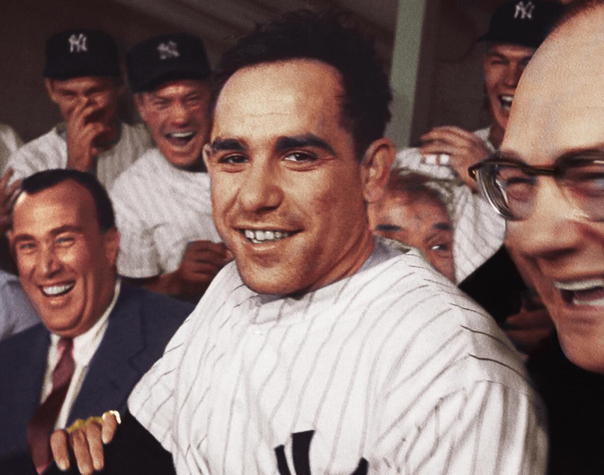 A young man in a pinstriped Yankees uniform, surrounded by smiling men in suits and uniforms.