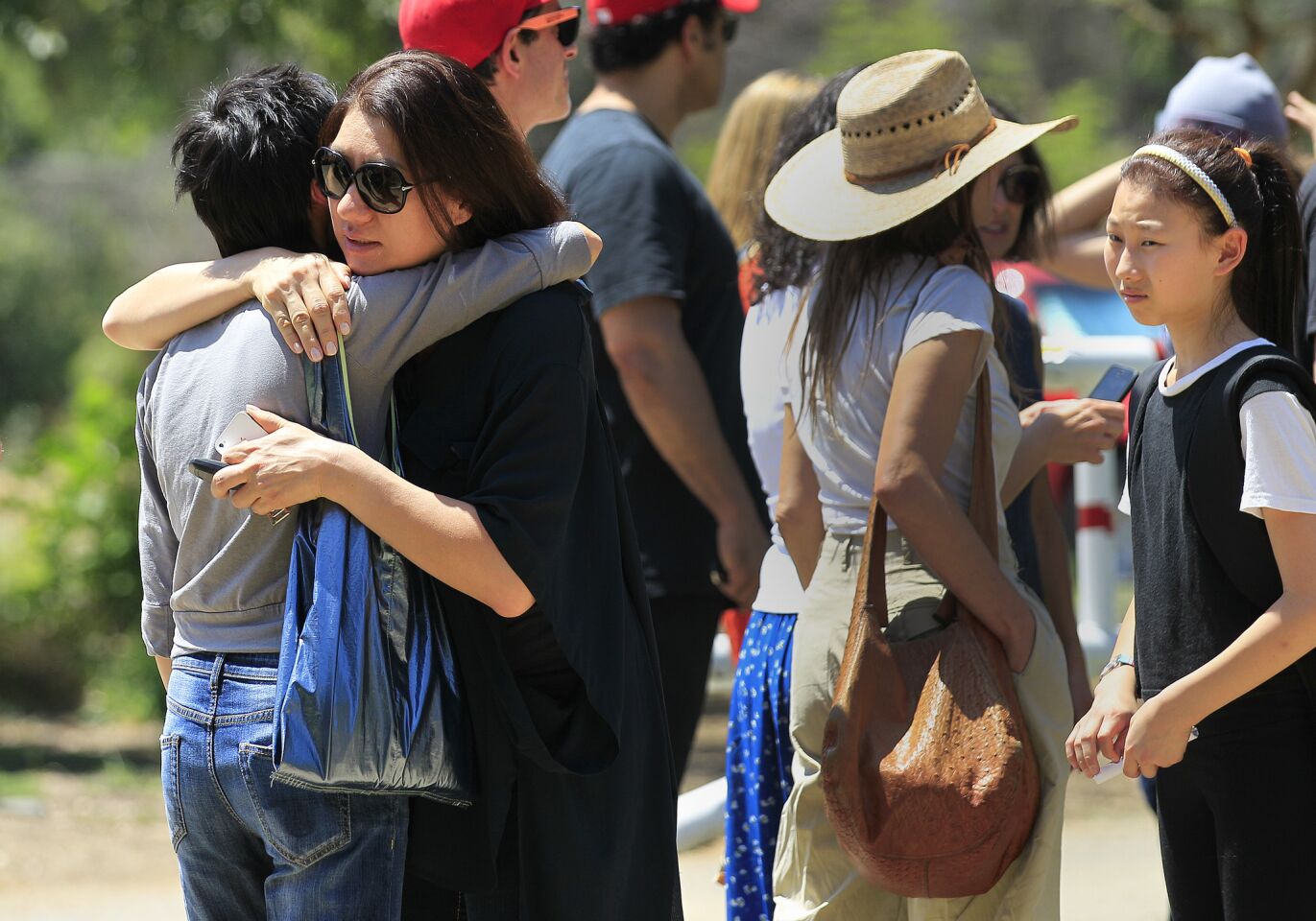 Parents hug as they wait to be reunited with their children who are being evacuated from Oakwood School in North Hollywood.