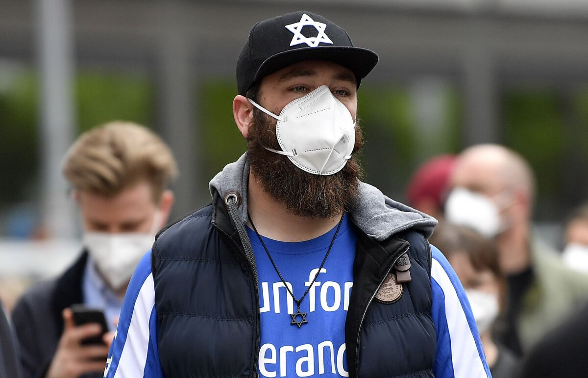 FILE --Hundreds of people keep a vigil at the synagogue in Gelsenkirchen, Germany, Friday, May 14, 2021. Germany's domestic intelligence agency said Wednesday that antisemitic crimes are continuing to rise and those that come to light are only “the tip of the iceberg.”(AP Photo/Martin Meissner,file)