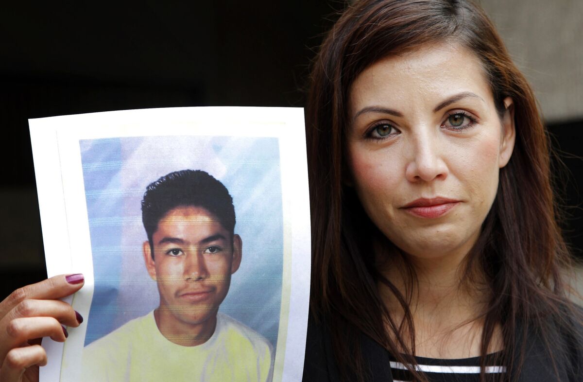 Lydra Espinoza Oregel holds a photo of her brother Edel Gonzalez at age 16 at a news conference in Los Angeles in 2013. Gonzalez, now 38, is the first inmate in California to have his life sentence for a crime committed as a youth reduced to allow for parole.