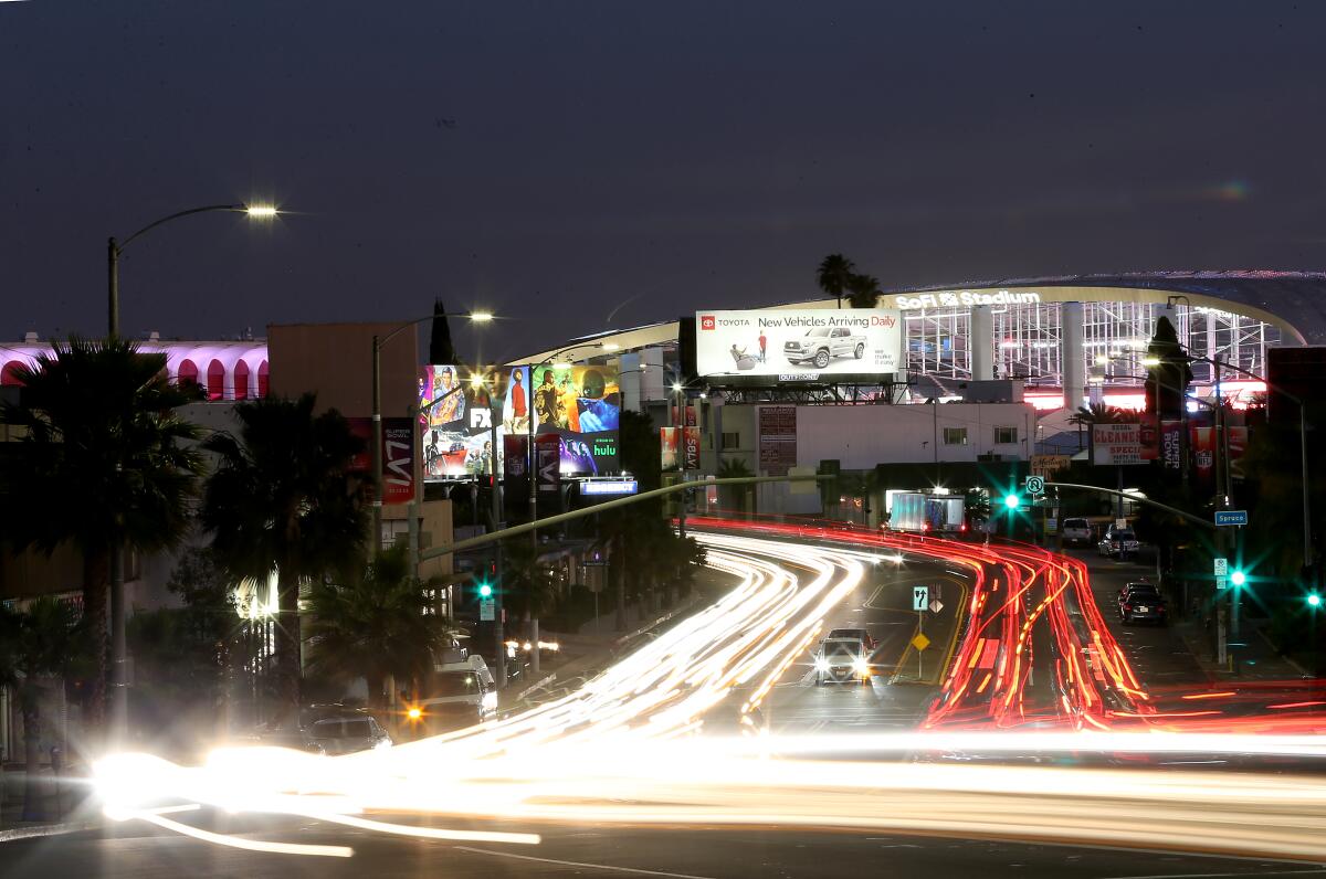 Car lights on roadways with SoFi Stadium in the background 