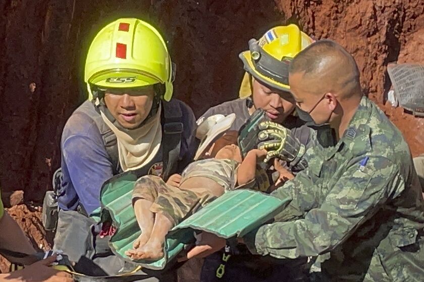 Following an overnight emergency operation, rescue workers and military carry a 1 year-old from a deep hole in the northern Thailand province of Tak, 420 kms. (260 miles) north of Bangkok, Tuesday, Feb. 7, 2023. The toddler, who is from Myanmar, fell into the 15 meter deep hole used for groundwater pipes yesterday evening. (AP Photo/Chiravuth Rungjamratratsami)