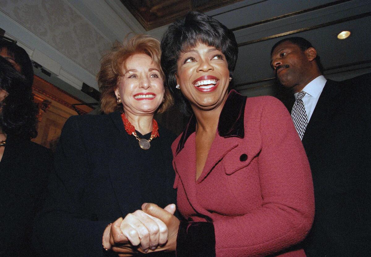 Oprah Winfrey is greeted by Barbara Walters, left, in 1994. 