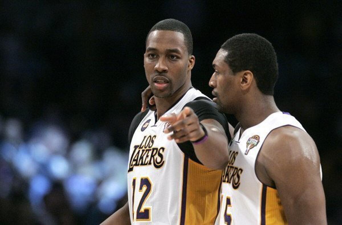 Lakers center Dwight Howard (12) and forward Metta World Peace discuss strategy.