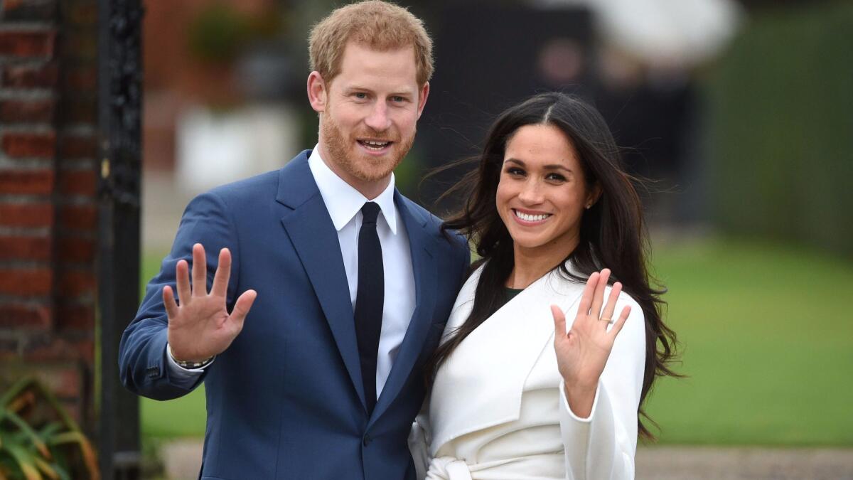 Prince Harry poses with his fiancee, actress Meghan Markle, after announcing their engagement in the Sunken Garden at Kensington Palace in London.