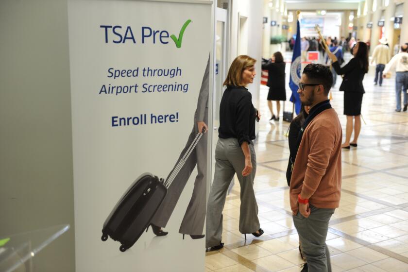 A poster announcing the new Precheck program is seen outside the PreCheck enrollment office at LAX.