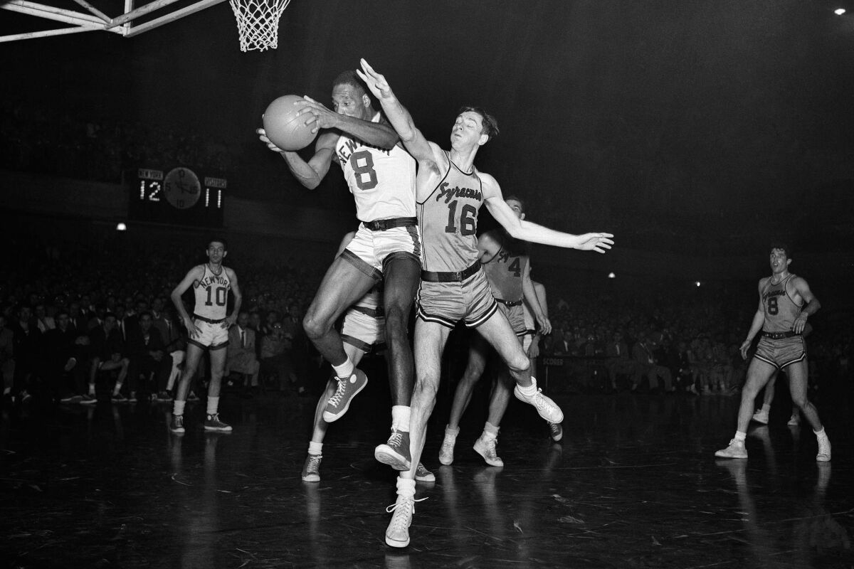 FILE - In this April 8, 1952, file photo, Nat "Sweetwater" Clifton (8), New York Knickerbockers' center, pulls in a rebound in the first quarter of the National Basketball Association Eastern playoff game against the Syracuse Nationals, at the 9th Regiment Academy Armory in New York. (AP Photo/Ed Ford, File)