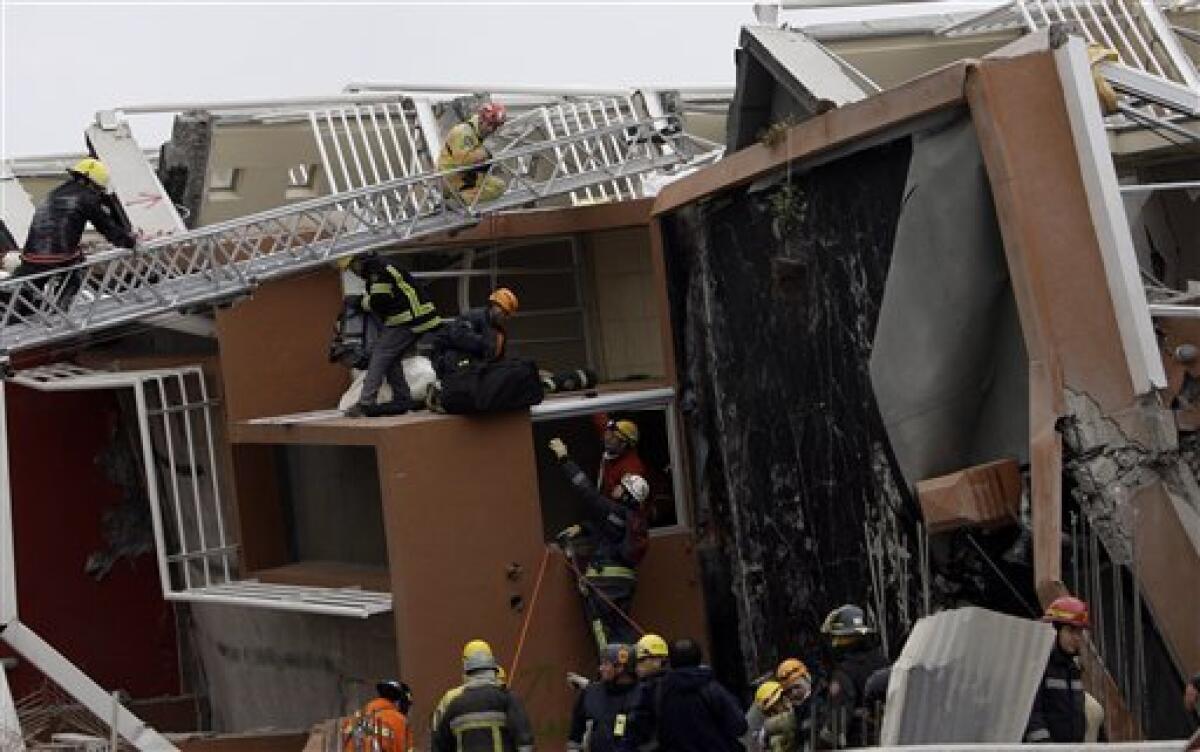 Rescue workers looks for earthquake victims in a collapsed building in Concepcion, Chile, Sunday, Feb. 28, 2010. A 8.8-magnitude earthquake hit Chile early Saturday. (AP Photo/ Natacha Pisarenko)