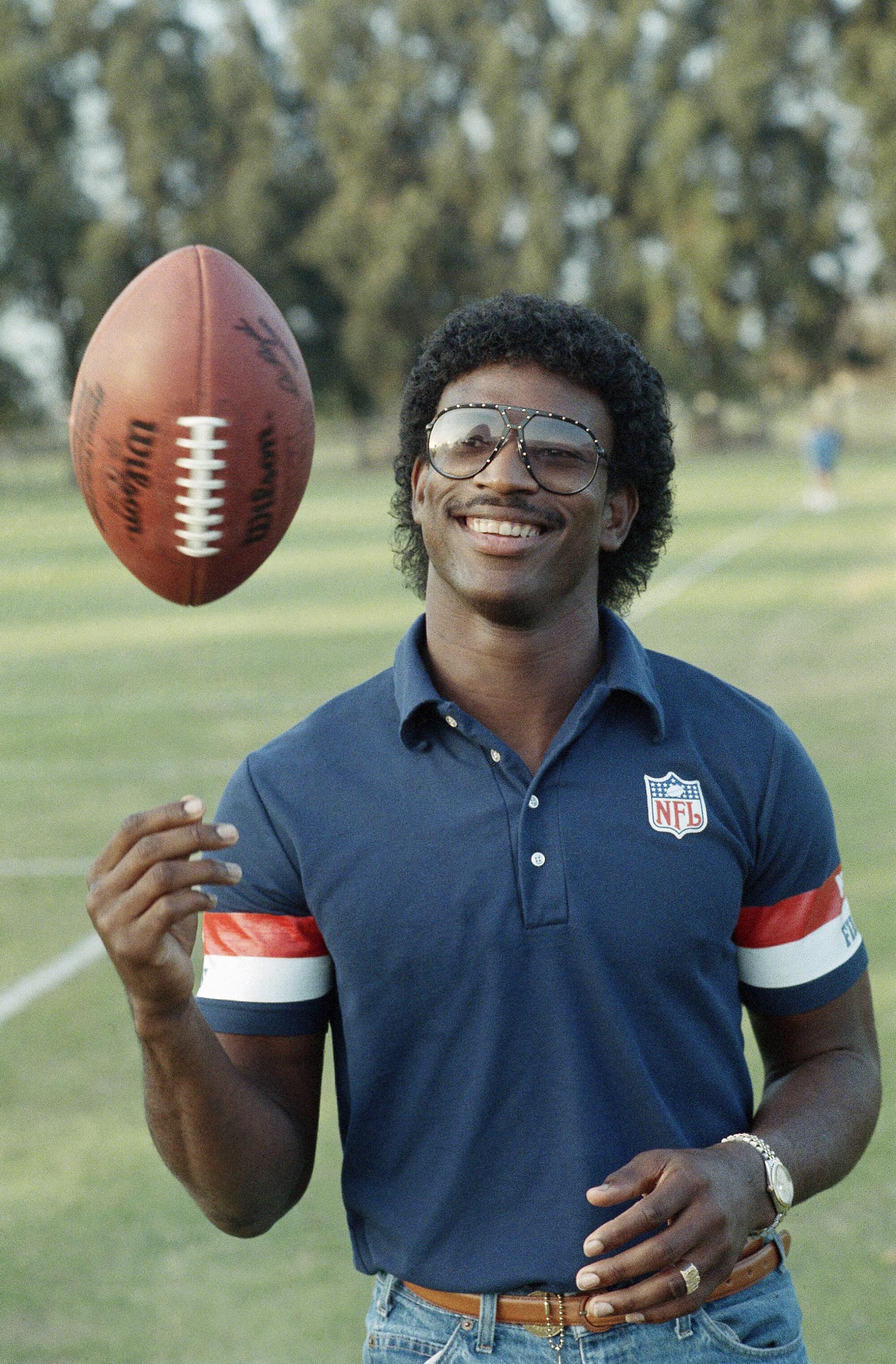 Rams running back Eric Dickerson tosses a football in December 1983.