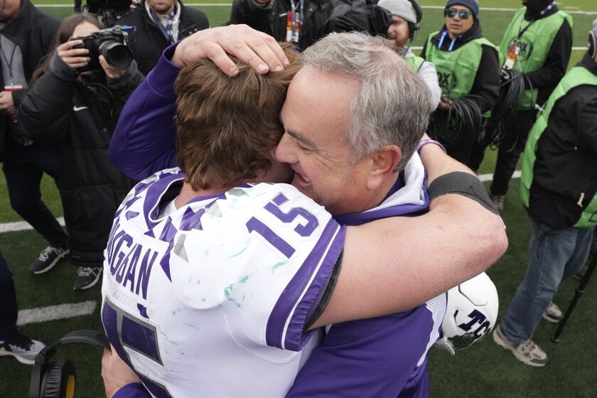FILE - TCU head coach Sonny Dykes, right, hugs quarterback Max Duggan (15) after an NCAA college football game against Bayor in Waco, Texas, on Nov. 19, 2022. Duggan’s 41st career start for third-ranked TCU will come in the Big 12 championship game on Saturday, Dec, 3, 2022, with the undefeated Horned Frogs on the brink of making the College Football Playoff. (AP Photo/LM Otero, File)