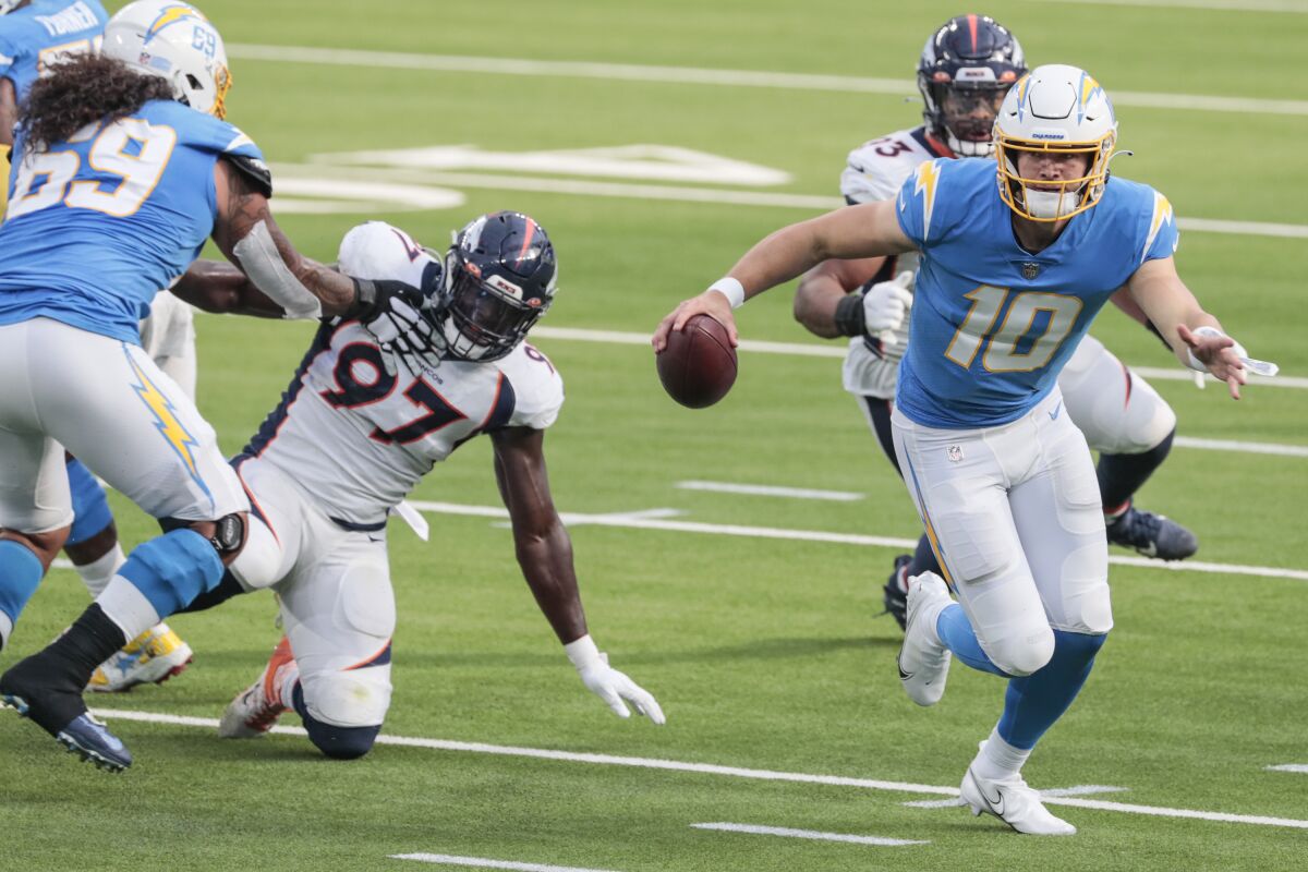 Chargers quarterback Justin Herbert scrambles out of the pocket against the Denver Broncos.