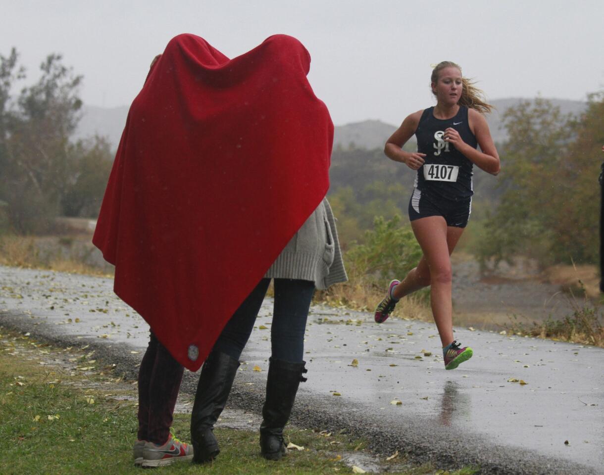 Spectators attempt to stay dry as they watch a race at Irvine Park as a light rain falls.