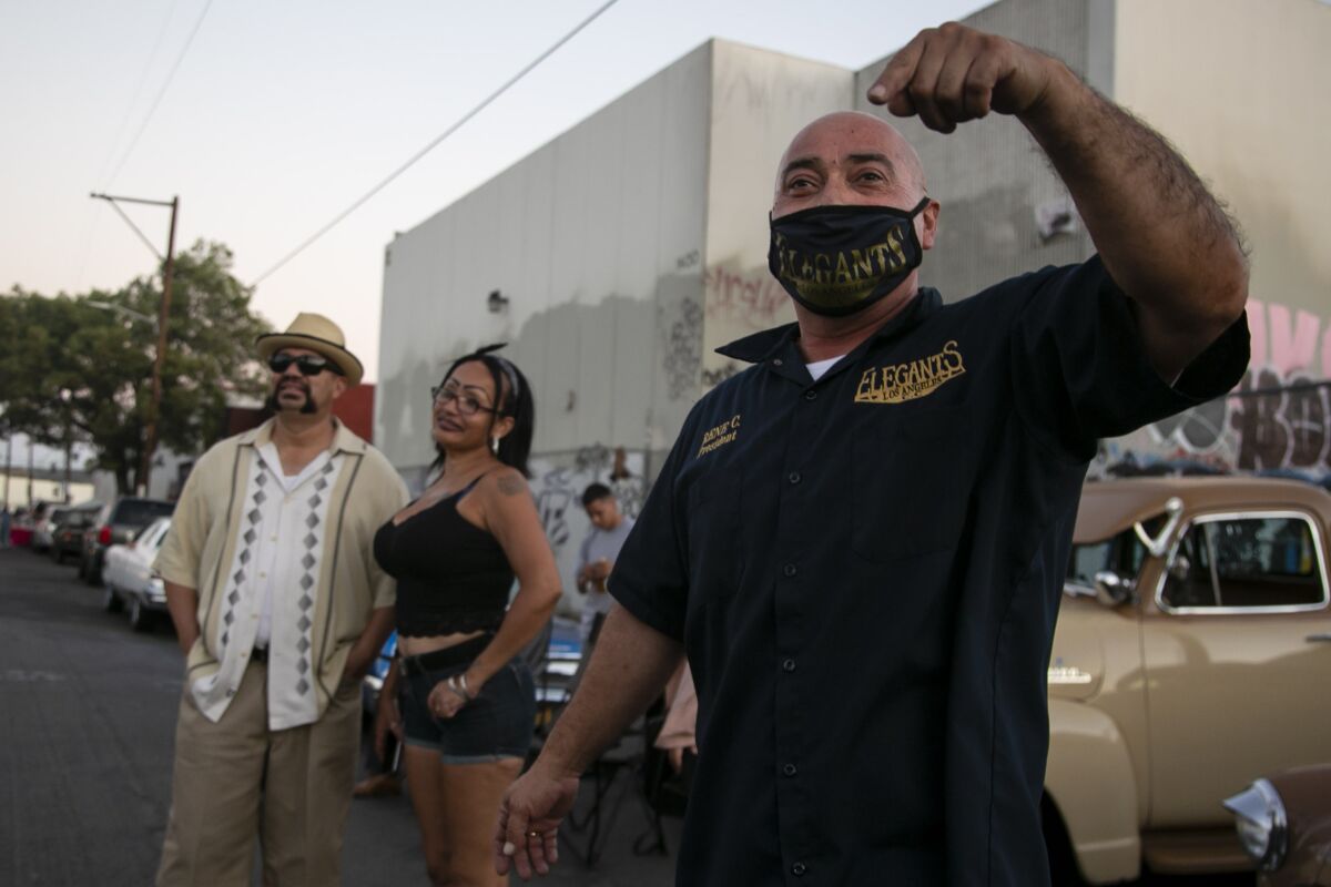 Rene Castellon of the Elegants Montebello car club teases friends from across the street during a gathering in L.A.