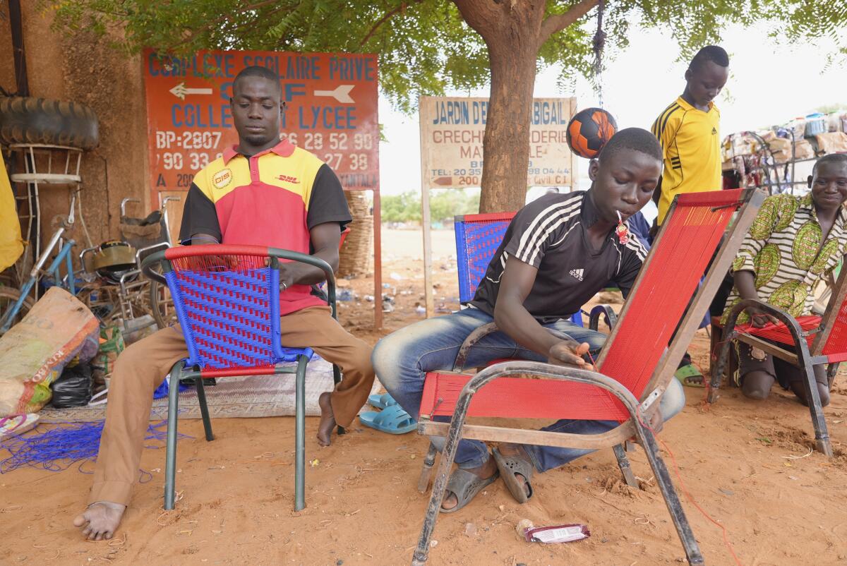 Two men repairing chairs in Niamey, Niger