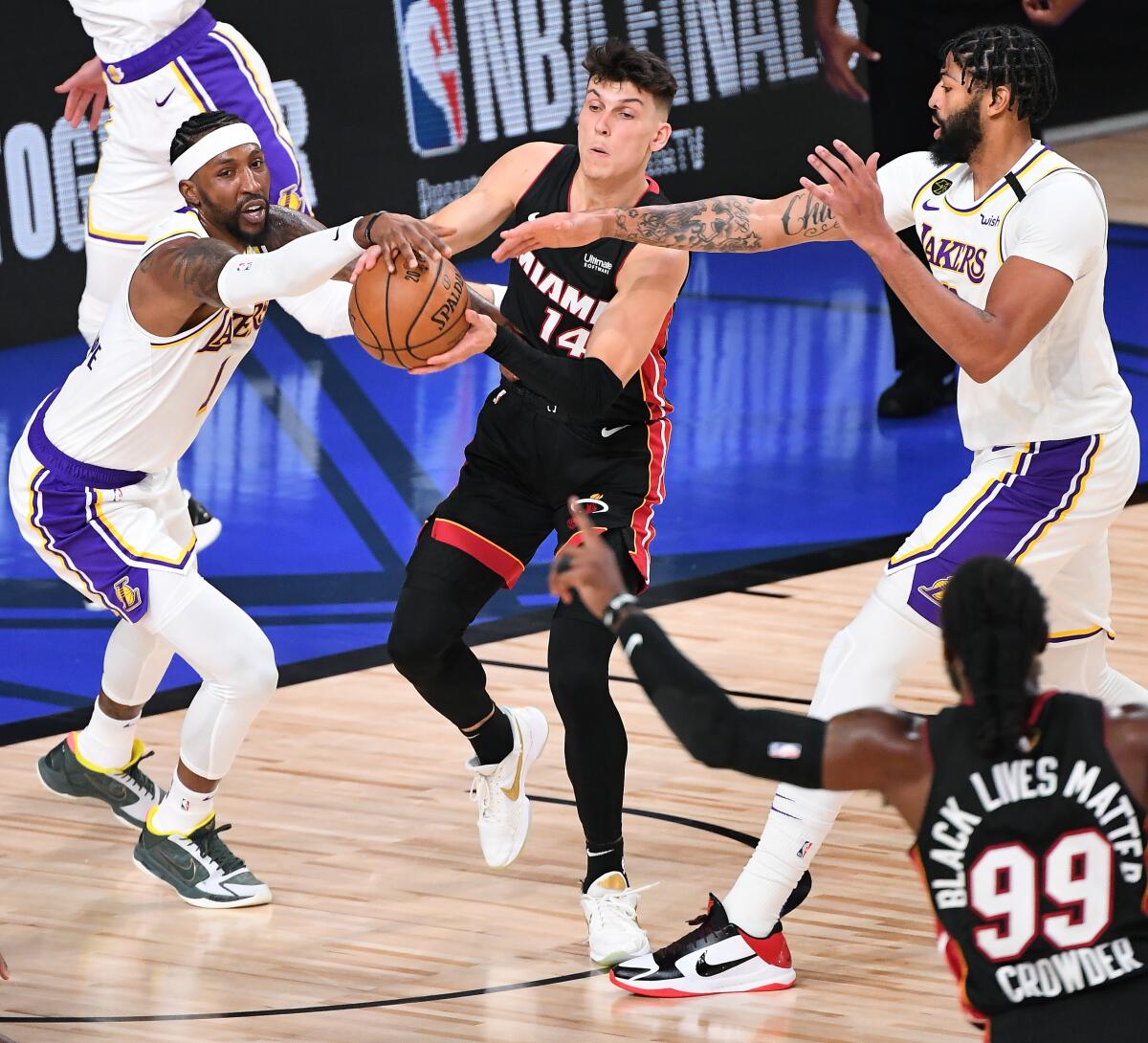 The Lakers' Kentavious Caldwell-Pope, left, and Anthony Davis apply defensive pressure to the Miami Heat's Tyler Herro.