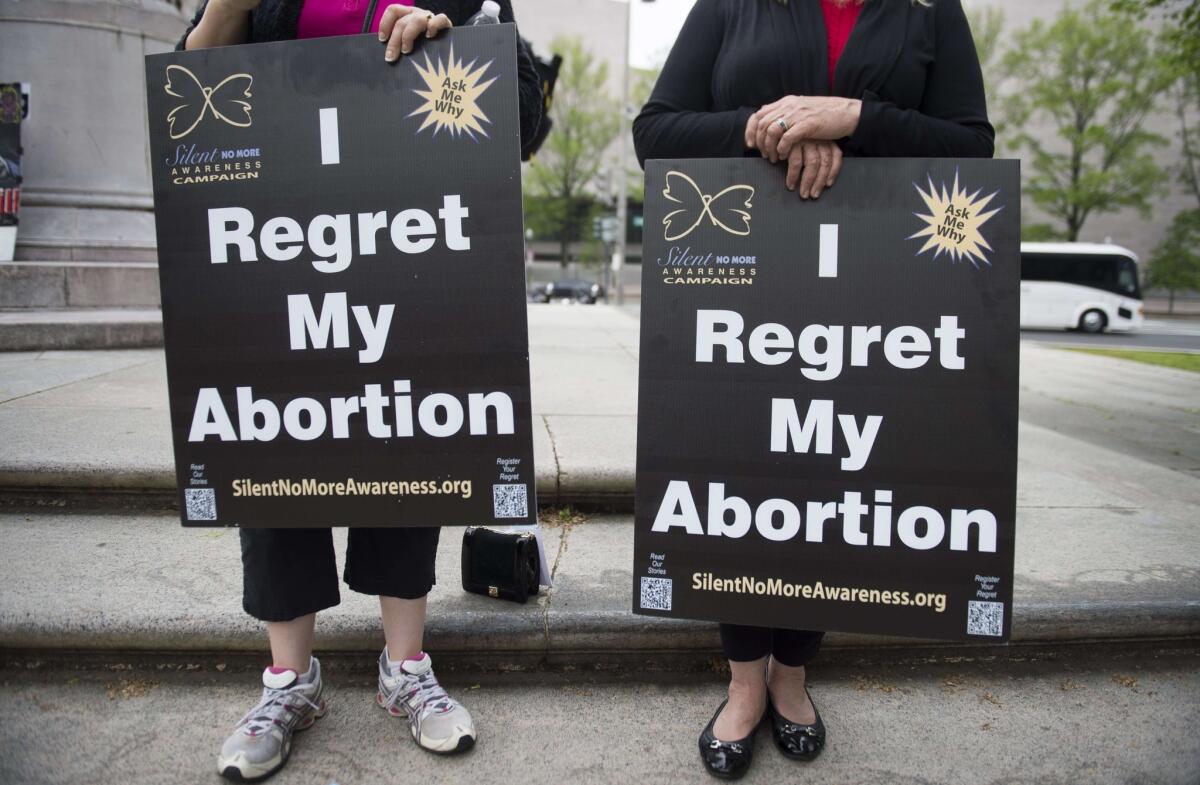 Anti-abortion demonstrators hold signs during a Priests for Life protest in Washington. 