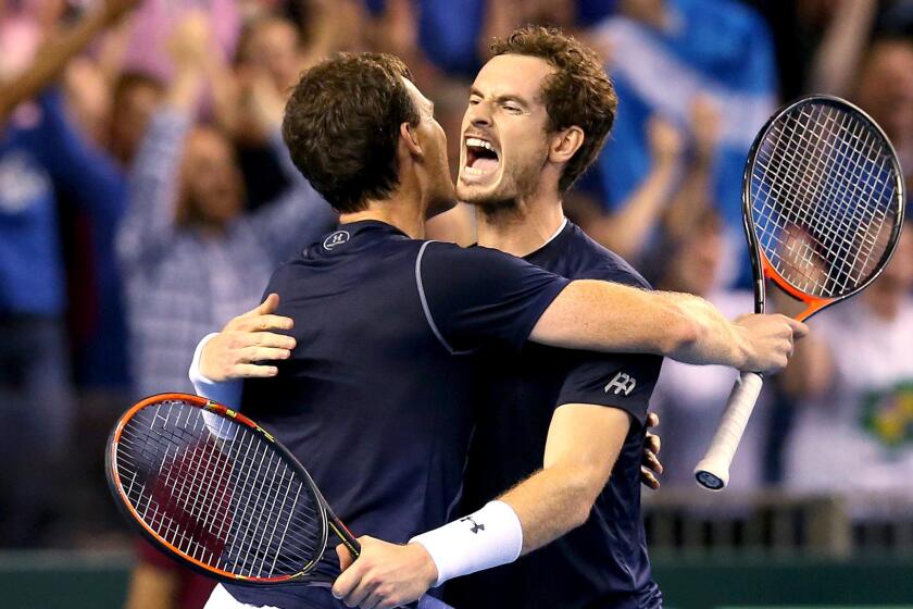 Brothers Jamie, left, and Andy Murray celebrate after defeating Australia's Sam Groth and Lleyton Hewitt in the doubles match during the Davis Cup semifinals on Saturday.