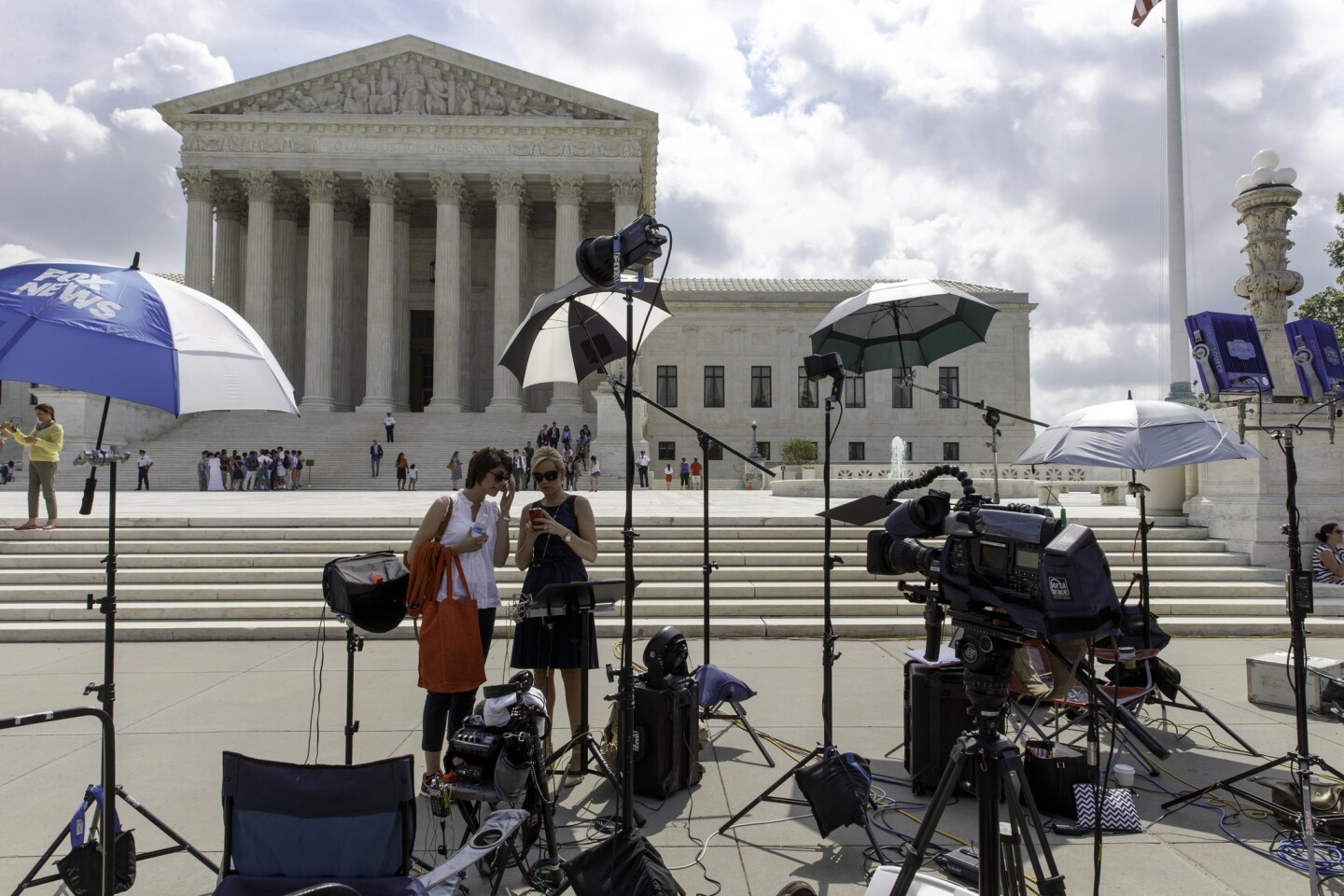 News media crews wait for the Harris vs. Quinn decision in the final days of the Supreme Court's term. The high court held that personal home-care employees cannot be forced to pay dues to a union, but it stopped short of extending the ruling to all public employees.