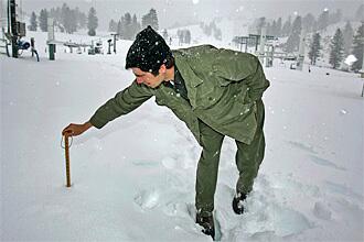 Kevin Somes measures the snowfall in Running Springs.