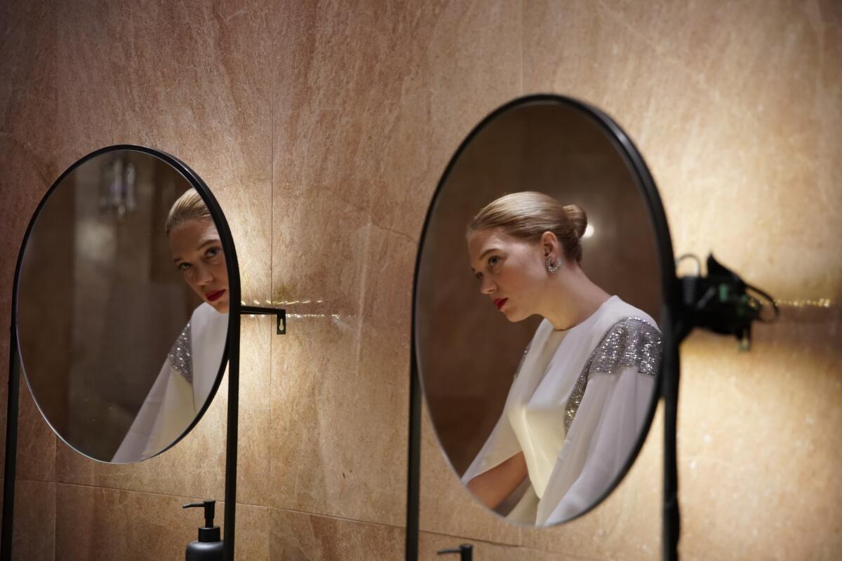 A woman's reflection is seen in two mirrors.