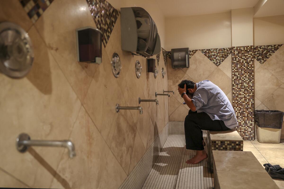 Osama Bin-Mahfouz, 27, washes himself before evening prayers at the Islamic Center of Southern California. The ICSC has issued precautionary measures for its congregants in response to the coronavirus. that includes a handshake, a hug, and a kiss on the cheek be avoided. The center believes it "may be worth avoiding touching" and that a hand on the heart, a respectful nod, and a warm smile are preferred. The center is asking sick members of faith to stay home and avoid Friday's traditional Jumma prayer. They are also asking that sick children at the center's New Horizon School system and Sunday School be kept home.