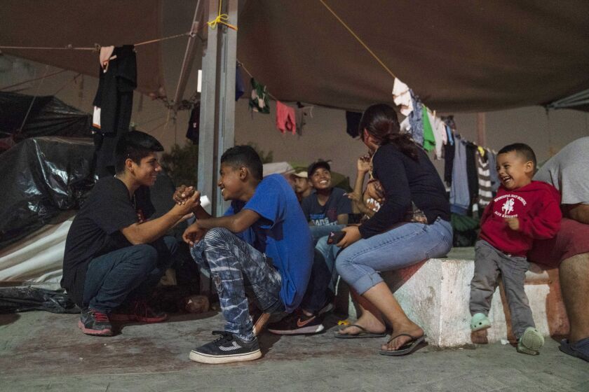 Central American asylum-seeking teenagers play in an encampment where they live near the Gateway International Bridge on Friday, Nov. 22, 2019 in Matamoros, Mexico. Verónica G. Cárdenas / For The Times