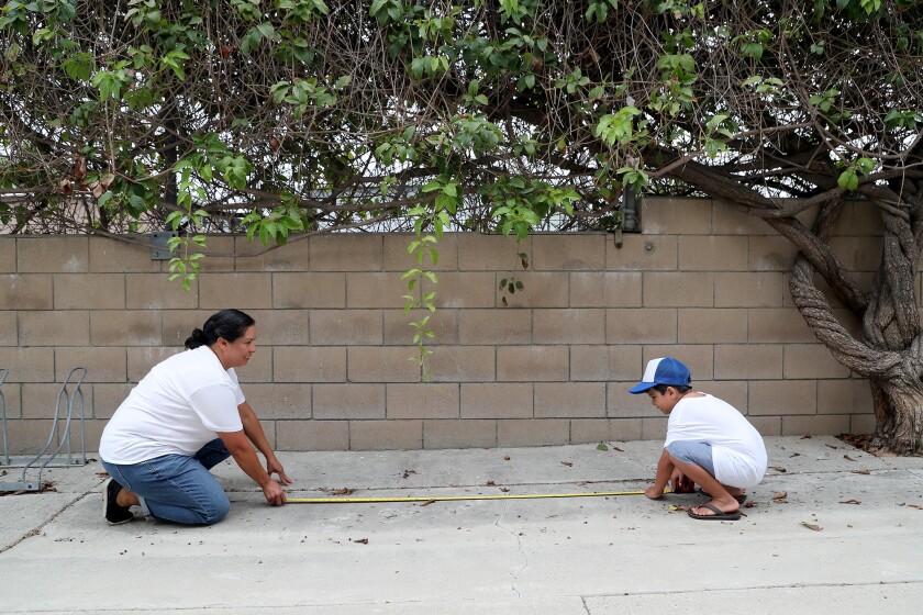 Daya Oyarzabal and her son, Salvador, take measurements as they plan to build his school's garden.