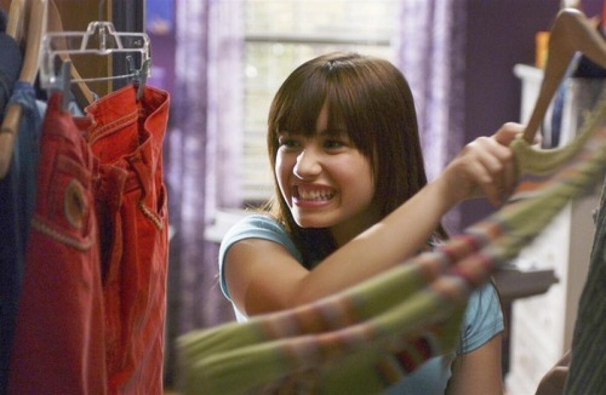 A young Demi Lovato rummaging through a closet of clothes in "Camp Rock."