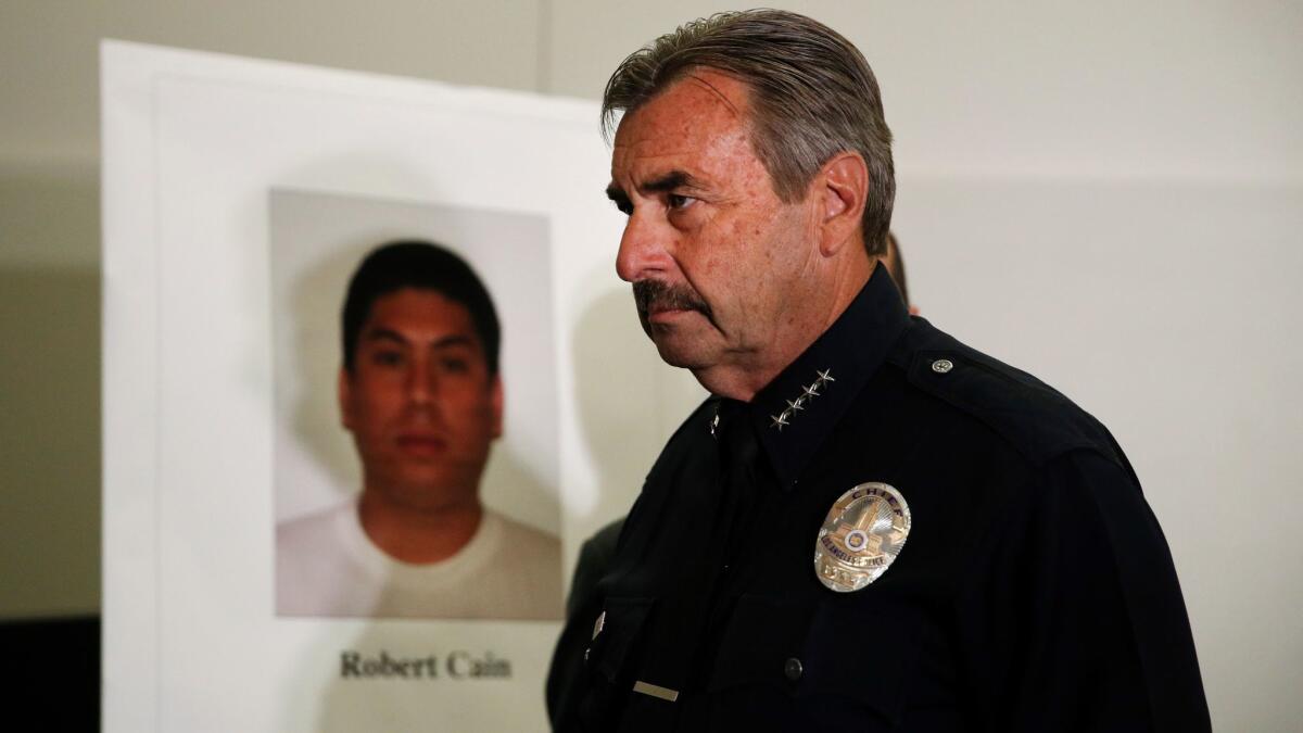 LAPD Chief Charlie Beck walks past an image of officer Robert Cain after a news conference on June 22 in Los Angeles. Cain was arrested for allegedly having sex with a 15-year-old cadet.