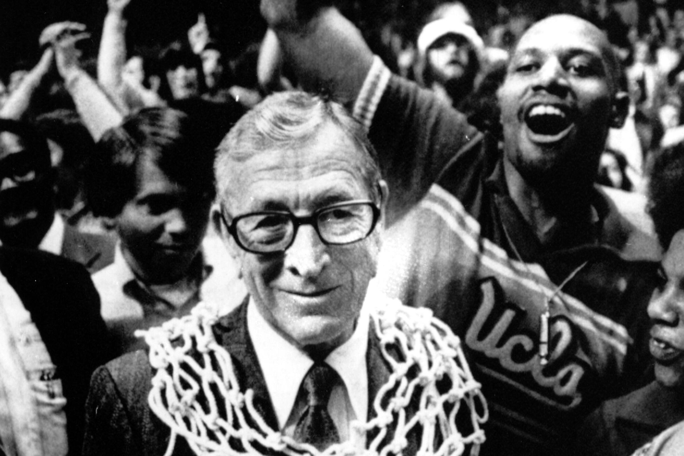 UCLA basketball coach John Wooden wears a basketball net around his neck after his team won the 1975 NCAA championship