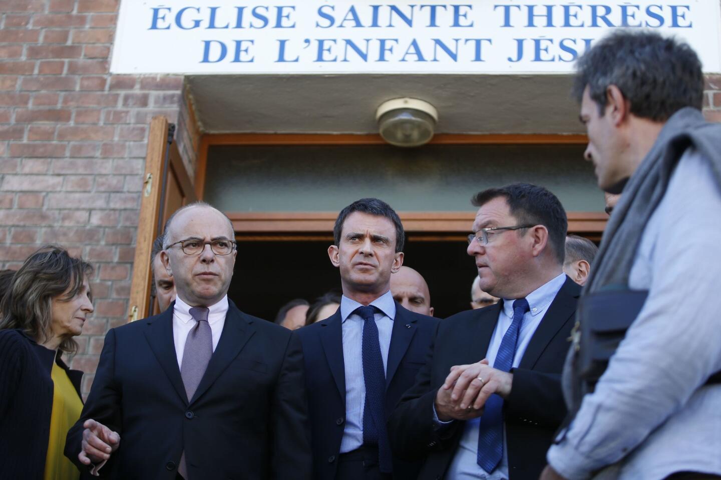 French Prime Minister Manuel Valls (C) and French Interior Minister Bernard Cazeneuve (L) and Villejuif's Mayor Franck Le Bohellec leave the Sainte Therese de l'Enfant Jesus.