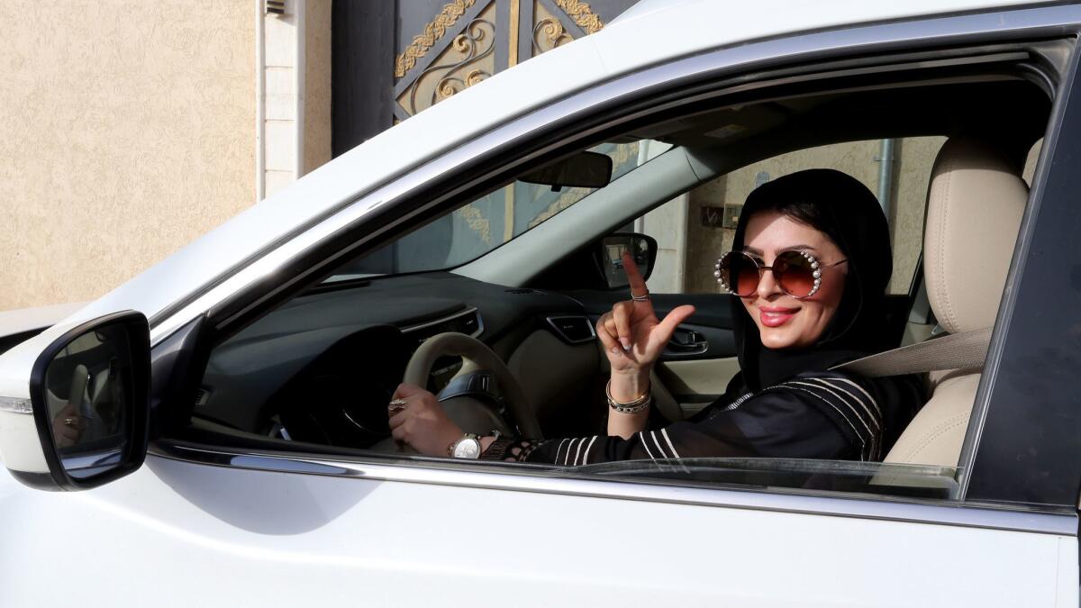A motorist poses behind the wheel in Riyadh on June 24, the day Saudi Arabia's ban on women driving cars was lifted.