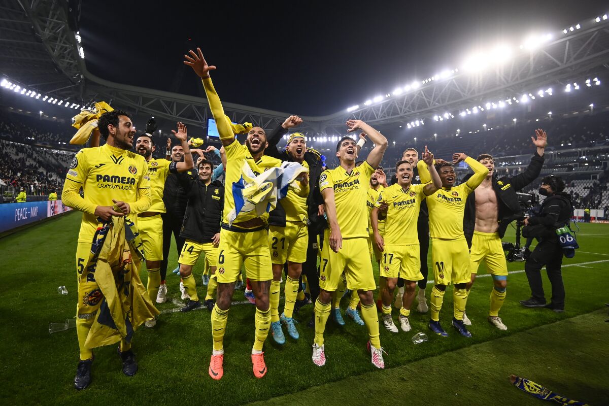 Villarreal players celebrate at the end of the Champions League, round of 16, second leg soccer match between Juventus and Villarreal at the Allianz stadium in Turin, Italy, Wednesday, March 16, 2022. Villarreal won 3-0. (Fabio Ferrari, LaPresse via AP)