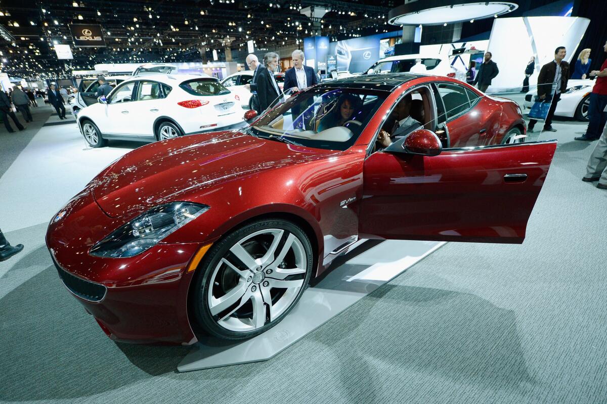 Fisker Automotive is back in business. The luxury car maker has signed a lease for a 550,000-square-foot manufacturing facility in Moreno Valley. In this 2012 photo, reporters gather around a Fisker Karma during the Los Angeles Auto Show.