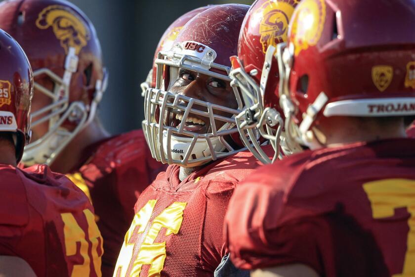 Former USC center Marcus Martin, center, smiles during a team practice session in October 2013.