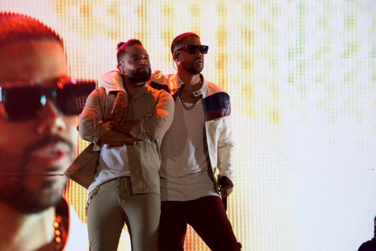 Henry Santos (izq.) junto a Romeo Santo durante su recorrido en el pasada gira "Inmortal" del Grupo Aventura.