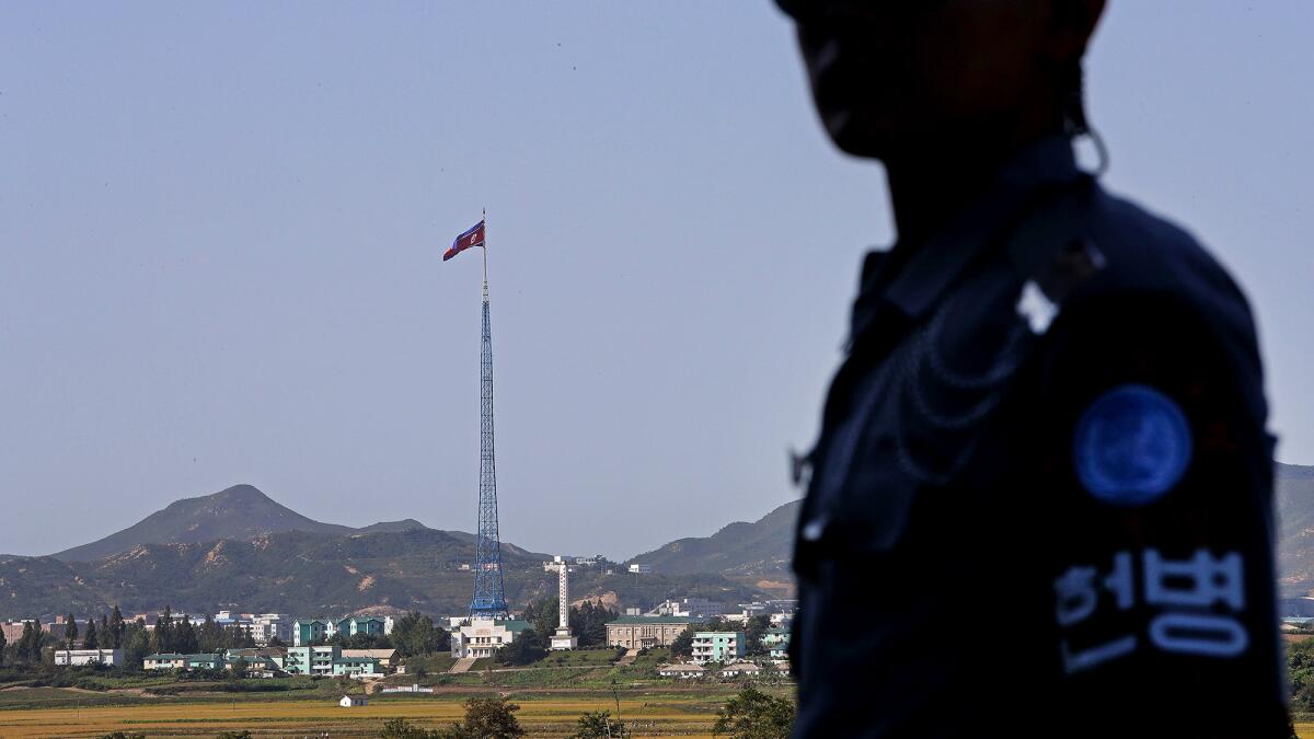 Music blares from loudspeakers in Kijong-dong, drifting eerily across the winter-browned countryside. A towering flagpole rises high above.